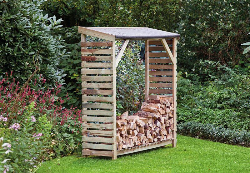 Abri pour cheminée bois pin vert imprégné B180 x D50 x H180 cm dans un jardin, idéal pour le rangement du bois.